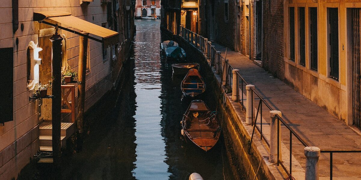 Plusieurs gondoles stationnées sur un des canaux de Venise - Les Escapades à Rome